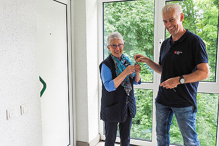 DRK-Mitarbeiter bringt einer Seniorin einen Schlüssel