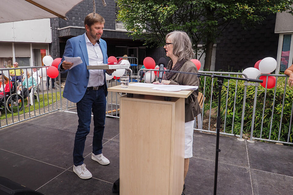 Frau schenkt Mann ein schweres Buch.