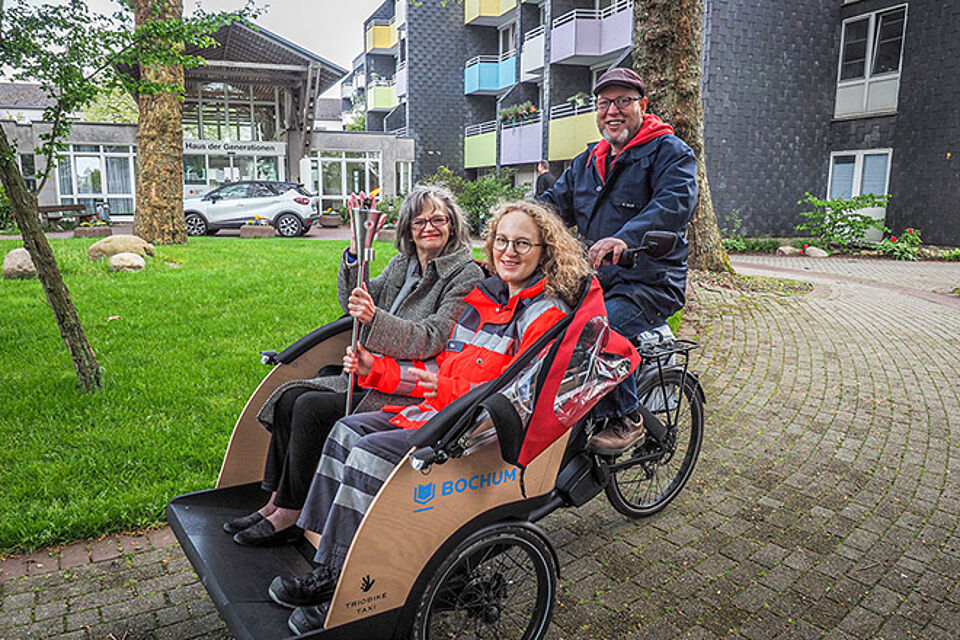Zwei Menschen werden in einer Fahrrad-Rikscha gefahren.