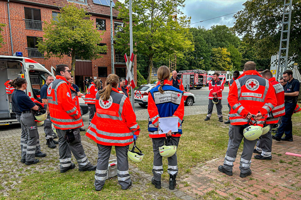 DRK-Sanitäter stehen im Kreis und besprechen den Einsatz.