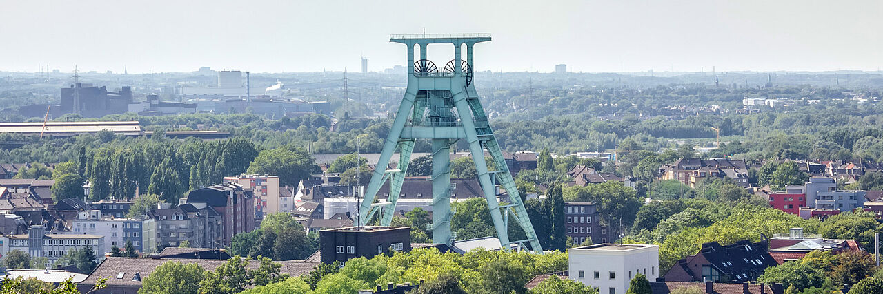 Blick über Bochum mit dem Förderturm des Bergbaumuseums in der Mitte.