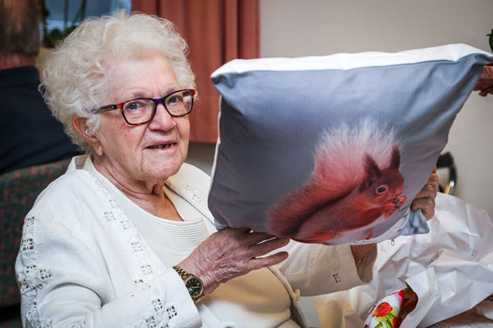 Kunigunde Ikler mit einem Kissen mit Eichhörnchenmotiv. 