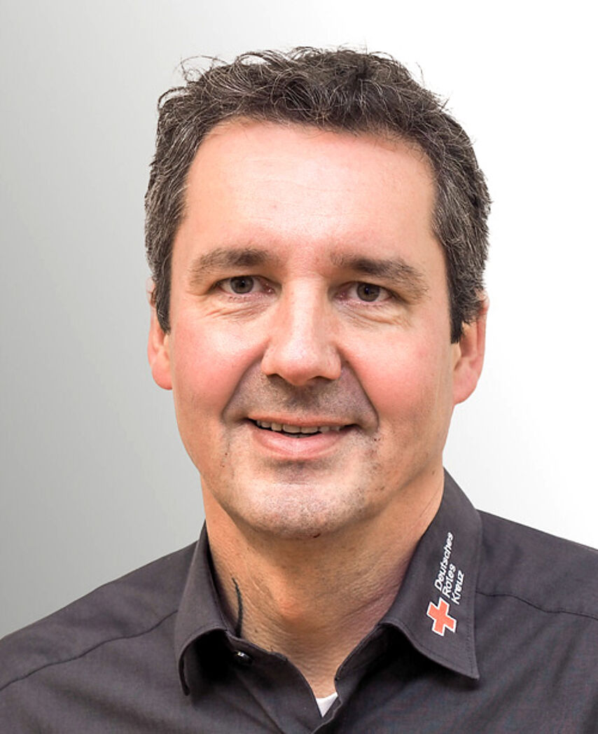 Mittelalter Mann mit dunklem Rotkreuzhemd.