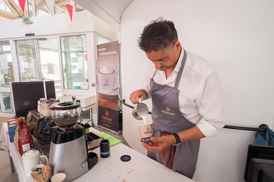 Barista schenkt einen Kaffee ein.