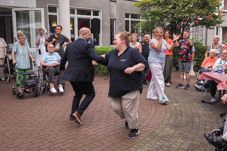 Ein Mann und eine Frau tanzen beschwingt im Kreis
