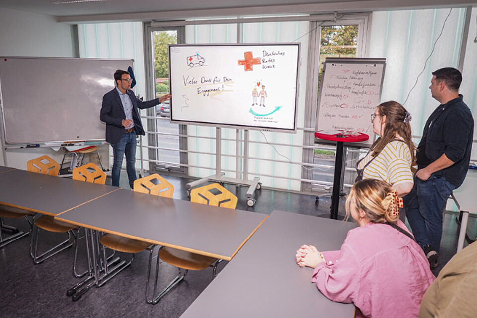 Mann demonstriert ein digitales Flipchart.