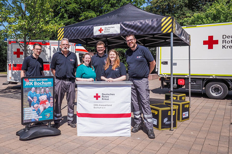DRK-Mitarbeiter stehen an einem Infostand