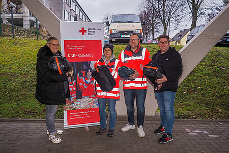 Zwei Betriebsratsvertreter der Stadtwerke Bochum übergeben Schlafsäcke an zwei Ehrenamtliche der Kältehilfe