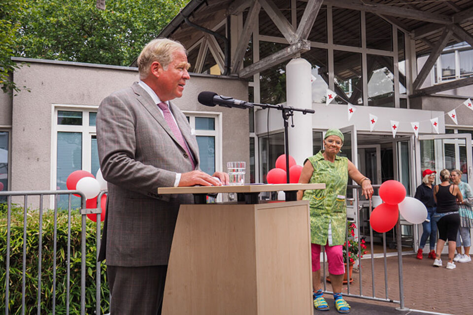 Mann in grauem Anzug an einem Rednerpult