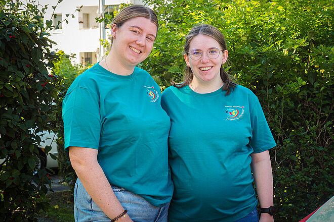 Zwei Frauen in petrolfarbenen T-Shirts des Jugendrotkreuz'.