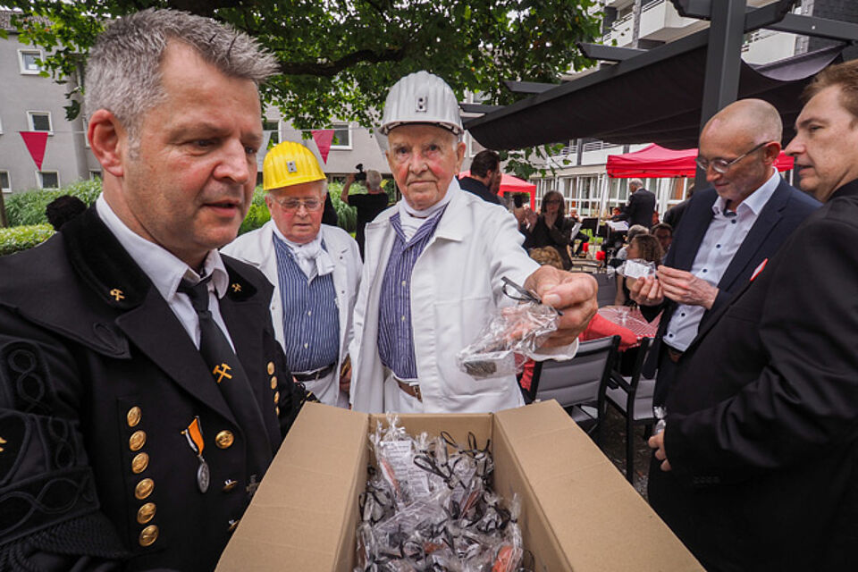 Drei Bergleute verteilen kleine Geschenke