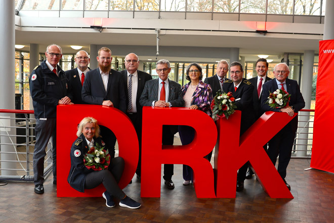 Eine große Gruppe versammelt sich hinter den Buchstaben "D", "R" und "K".