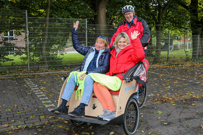 Zwei Damen in einer Fahrrad-Rikscha zusammen mit dem Rikschapiloten.