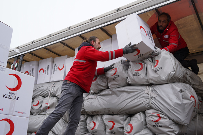 Helfer vom Türkischen Roten Halbmond entladen Hilfsgüter von einem LKW