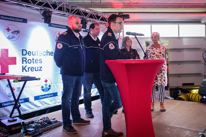 Die Kreisrotkreuzleiter Sebastian Oestreich, Jürgen Semmler und Janek Scholz stehen mit Präsidentin Dr. Ottilie Scholz und Esther Münch ("Walli") auf einer Bühne.