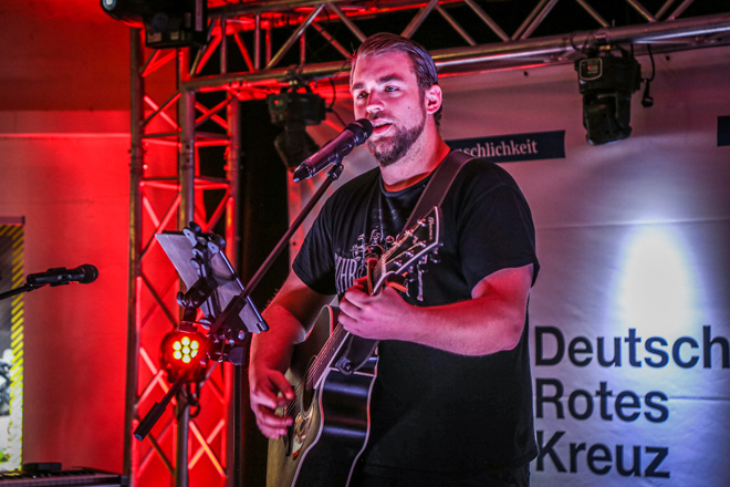 Fabian Kitschukov spielt Gitarre und singt.