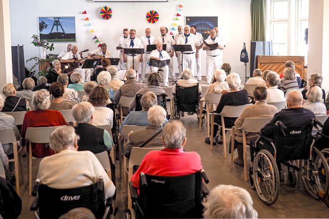 Männerchor vor betagtem Publikum.