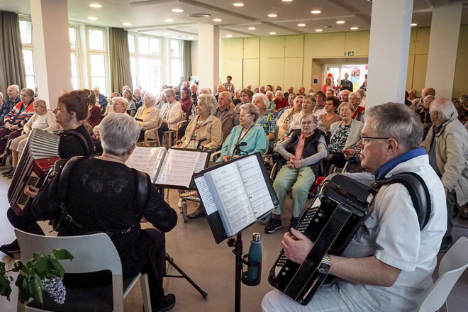 Musiker mit Akkordeon vor großem Publikum.