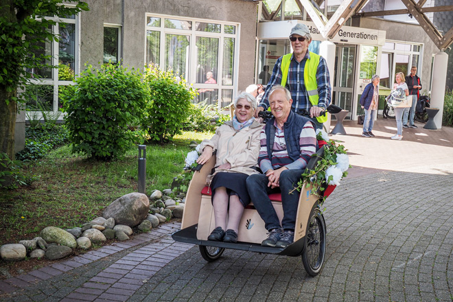 Zwei Senioren werden in einer Fahrradrikscha gefahren.